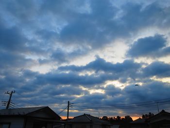 Low angle view of silhouette roof against sky