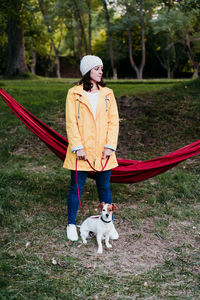 Full length of woman with dog on field