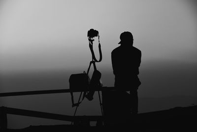 Rear view of silhouette man photographing against sky