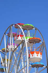 Low angle view of ferris wheel against clear blue sky