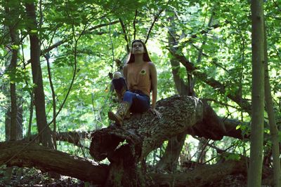 Portrait of man sitting on tree