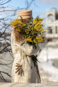 A  woman with a yellow acacia flowers. the concept of the spring - march 8, easter, women's day