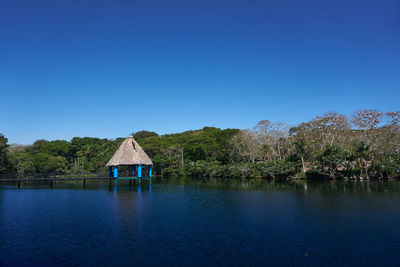 Scenic view of lake against clear blue sky