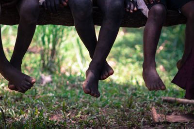 Low section of children legs over field