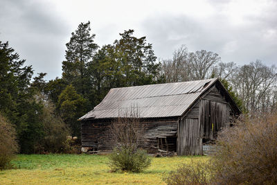 Abandoned house on field against sky