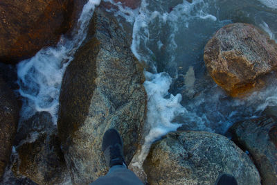 Low section of man on rock at beach