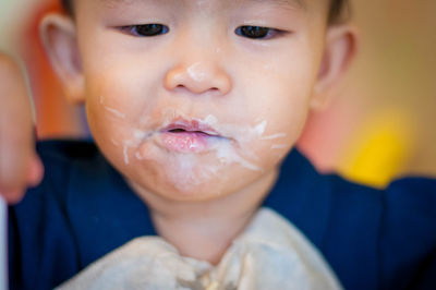 Close-up portrait of cute boy eating at home