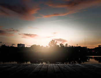 Scenery of wooden pier with dramatic sky sunrise above the pond