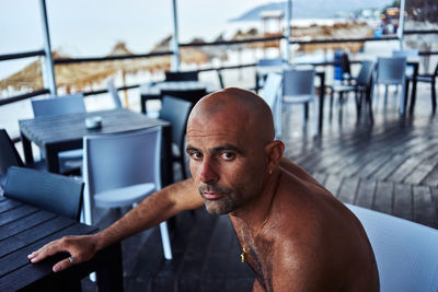 Portrait of shirtless man sitting at resort
