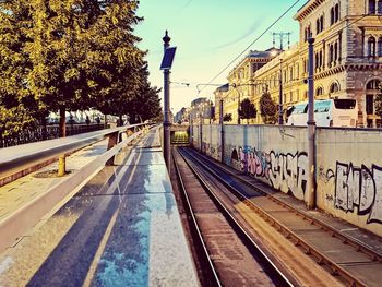 Railroad tracks in city against sky