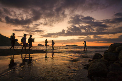 People on beach at sunset