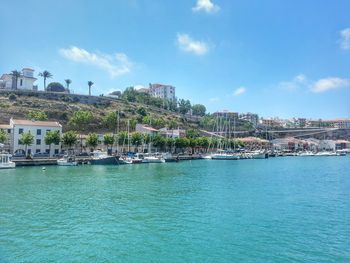 Boats moored in harbor with buildings in background