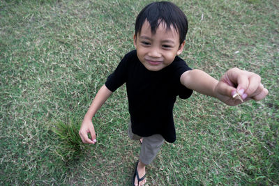 Portrait of boy standing on grassy field