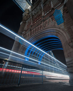 Light trails on road against buildings at night