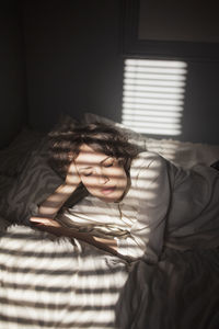 Portrait of young woman relaxing on bed at home