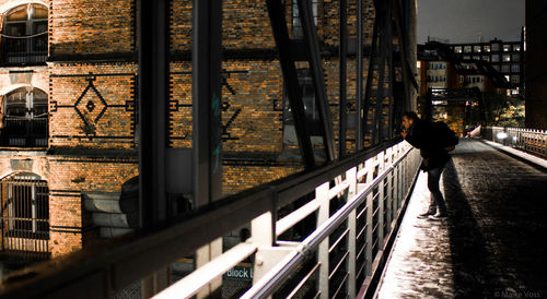 Man walking by railing in city