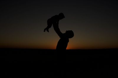 Silhouette woman standing against sky during sunset