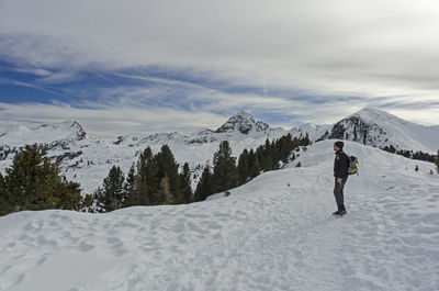 Rear view of man on snowcapped mountain against sky