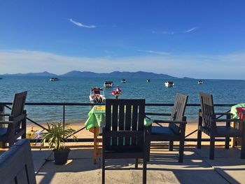 Chairs on beach against sky
