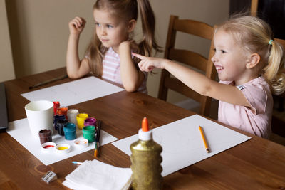 Cute girl sitting by table for drawing at home