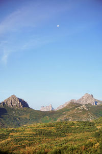 Scenic view of mountains against blue sky