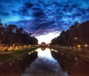 Arch bridge over river against sky at night