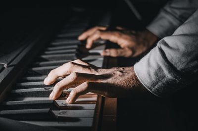 Midsection of man playing piano