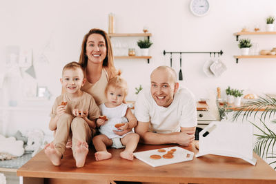 Happy big family of mom dad two kids cooking together and having fun in the kitchen at home