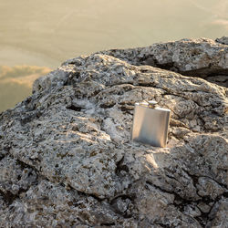 Close-up of hip flask on rock