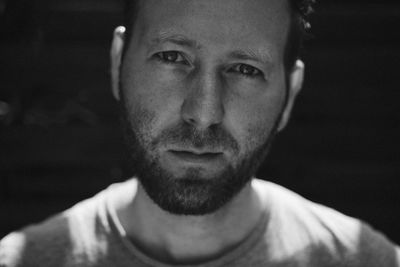 Close-up portrait of serious man in darkroom