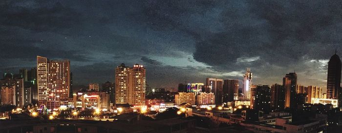 Panoramic view of illuminated cityscape against sky at night