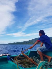 Rear view of man in sea against sky