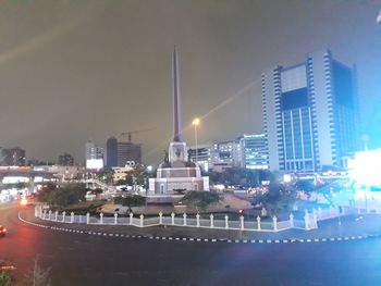 Illuminated buildings in city against sky at night