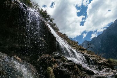 Scenic view of waterfall against sky