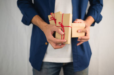 Midsection of child holding toy while standing in box