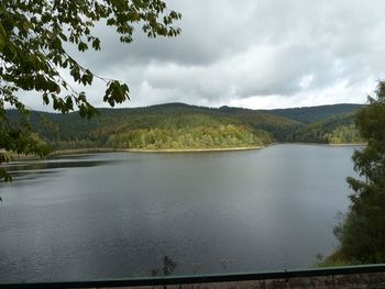 Scenic view of lake by mountains against sky