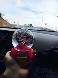 Hand holding ice cream cone in car