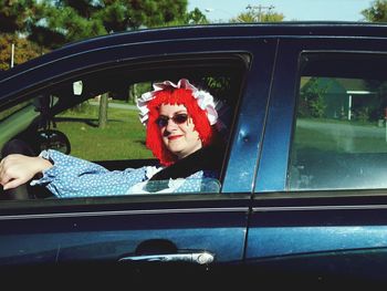 Portrait of woman wearing costume sitting in car