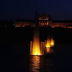 Illuminated building against clear sky at night