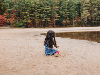 Girl playing by lake on a lovely autumn or fall day