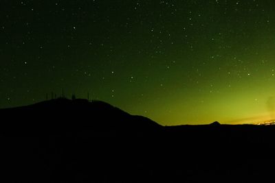 Low angle view of silhouette mountain against sky at night