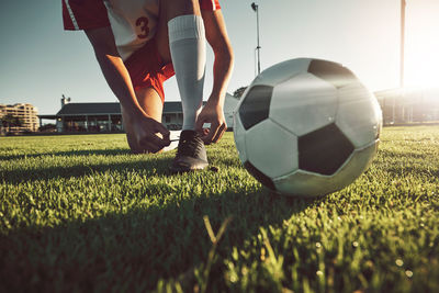 Low section of man playing soccer on field