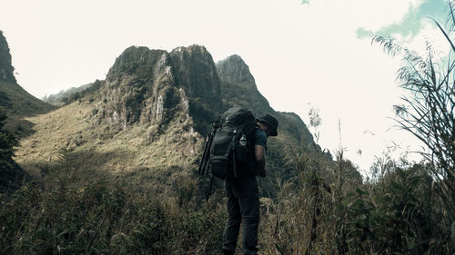 A man is standing alone among the mountain