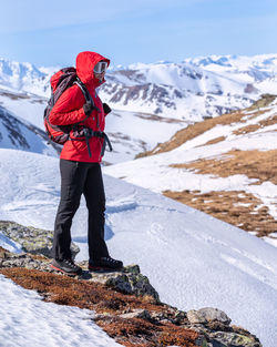 Full length of person standing on snowcapped mountain