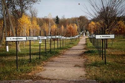 Road sign on field against sky