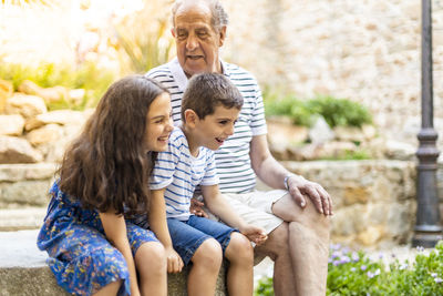 Smiling grandchildren with grandfather at park