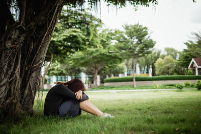 Full length of woman relaxing on field