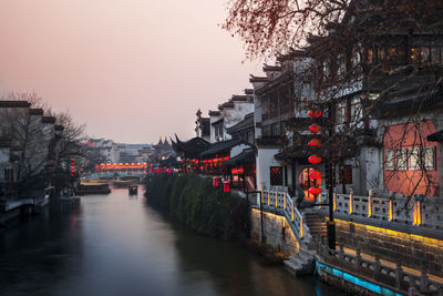 Bridge over canal in city at dusk