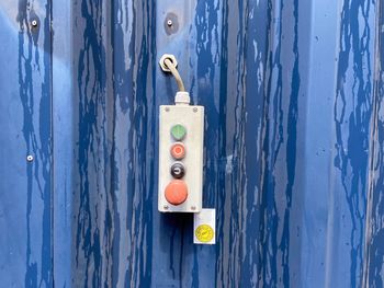 Close-up of switch board on blue wall