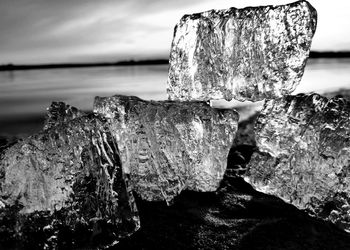 Close-up of rocks on shore against sky